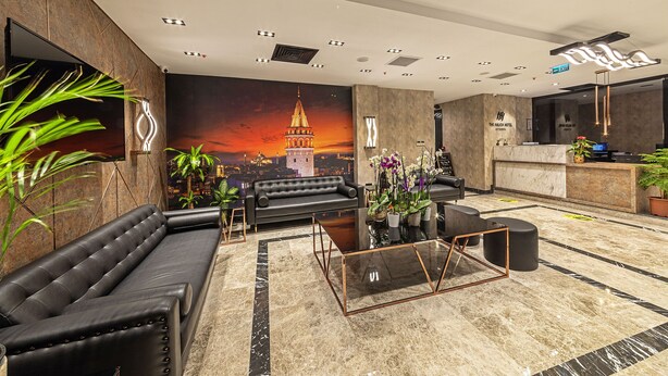A modern hotel lobby with a large sofa, a glass coffee table, and a reception desk. - The Halich Hotel Istanbul Karakoy (Istanbul)