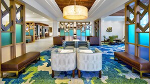 A lobby with a central seating area, wooden ceiling, and patterned carpet.