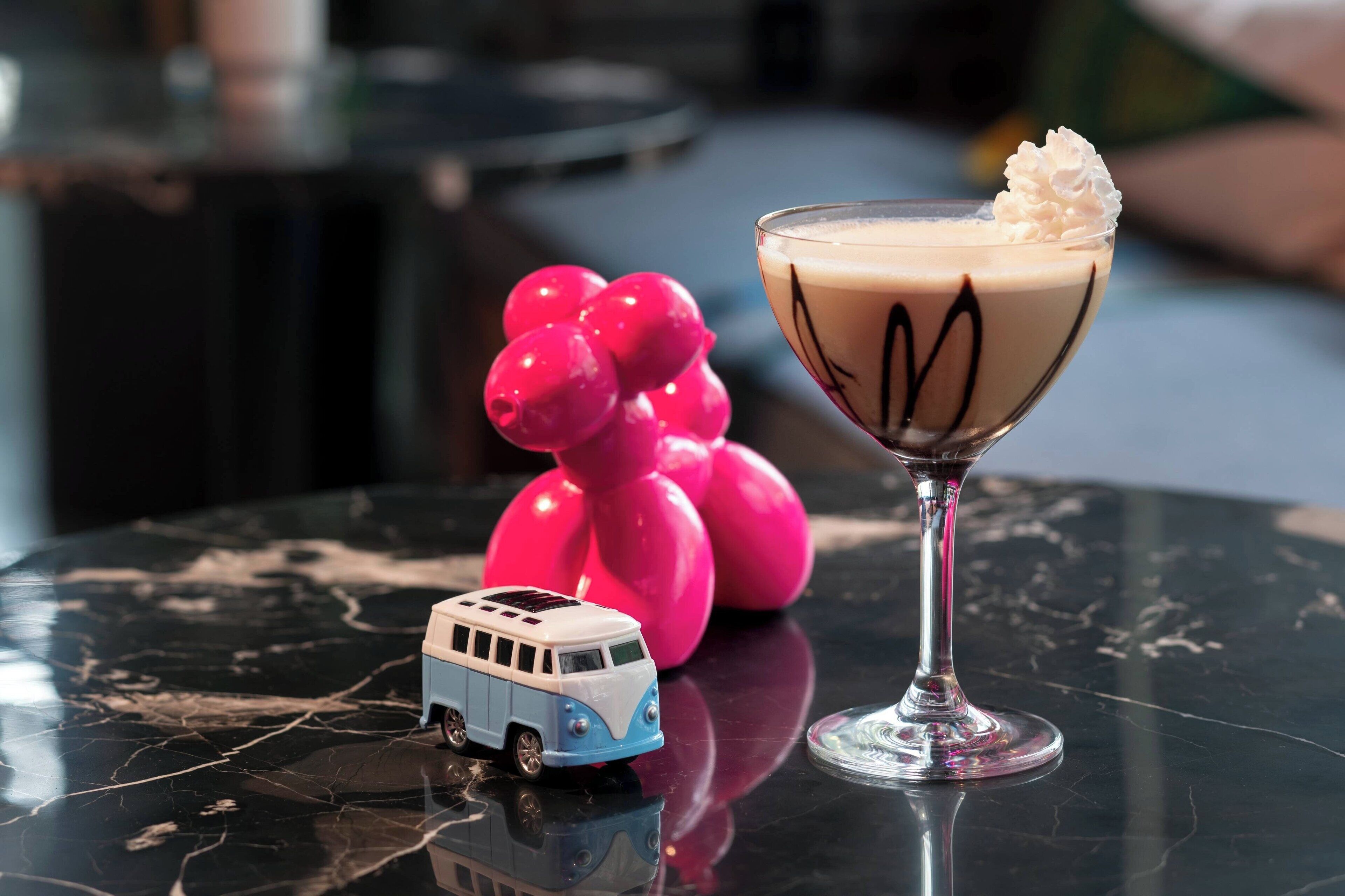 A martini glass with whipped cream on a reflective surface.