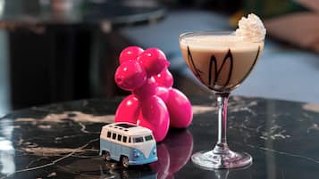 A martini glass with whipped cream on a reflective surface.