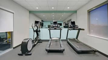 A fitness center with treadmills, stationary bikes, and elliptical machines.