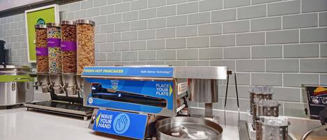 A self-service food station with a variety of snacks and a hot food dispenser.