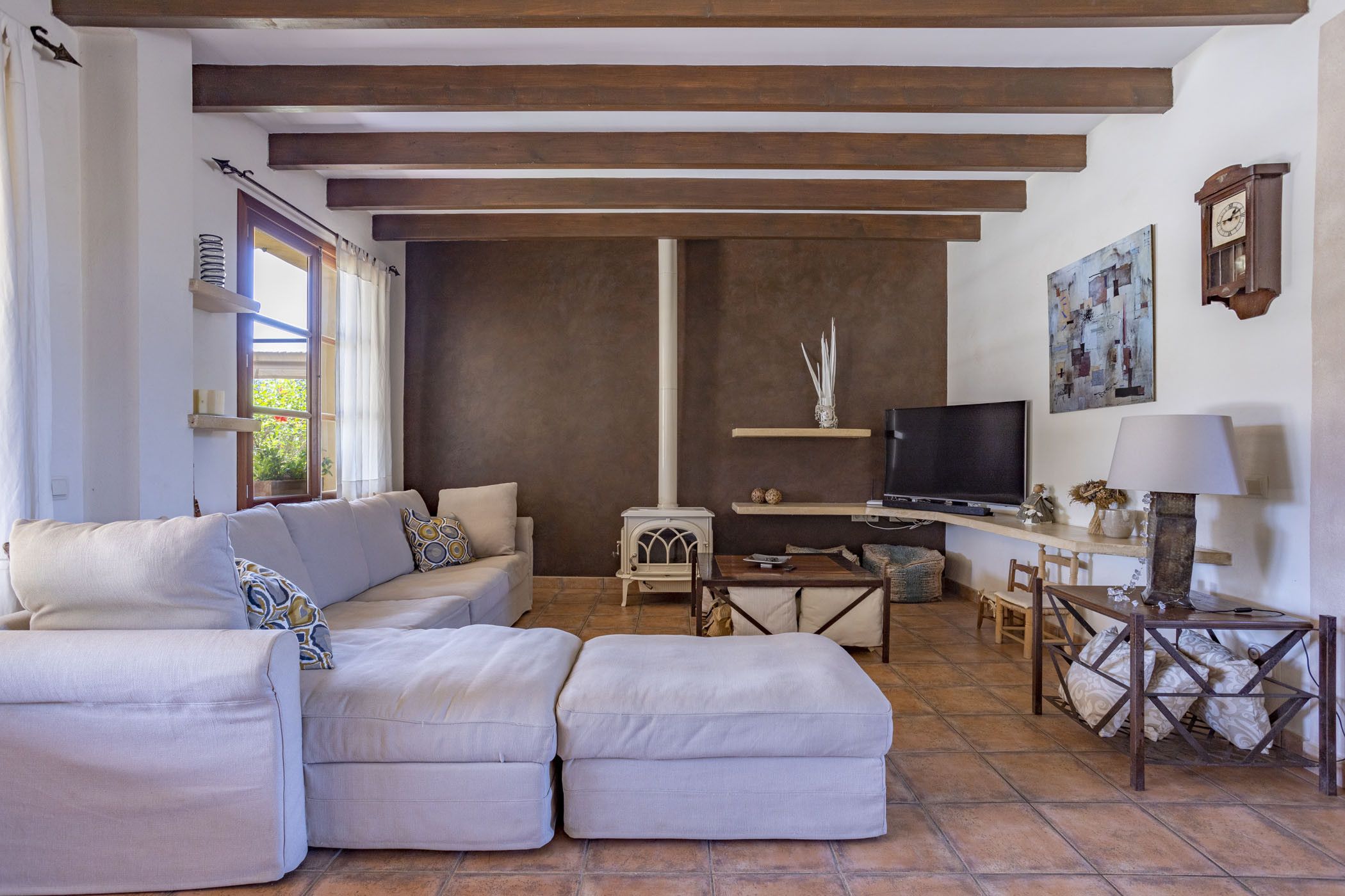 Una sala de estar con sofá, televisión, mesa y chimenea.