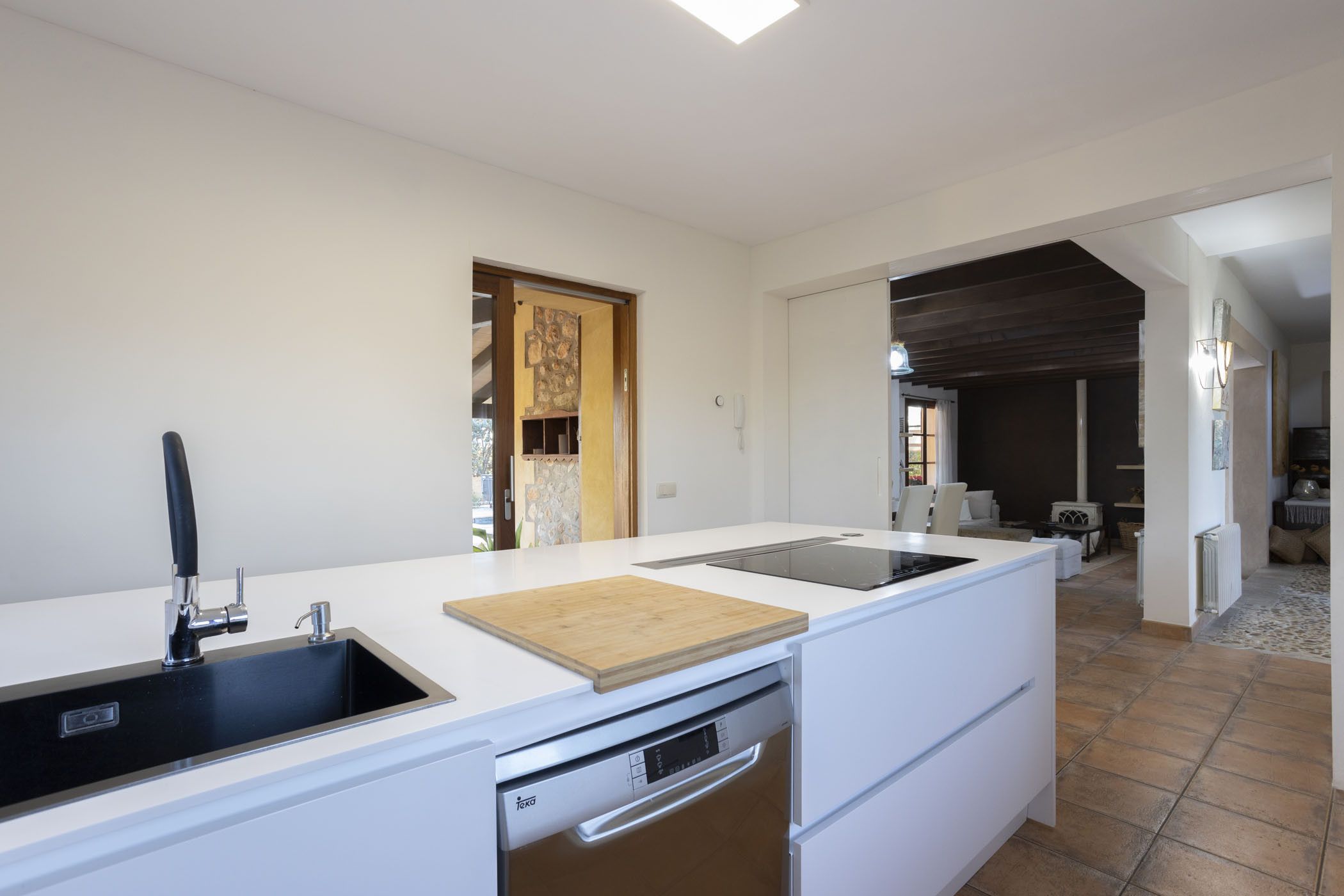 Una cocina moderna con lavavajillas integrado, tabla de cortar de madera y un lavabo.