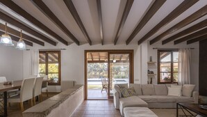 A spacious living area with a large sofa, a dining table with chairs, and a kitchen area visible through an open door. - Fantastic villa with 4 bedrooms, 3 bathrooms, wifi, barbecue, terraces and pool (Binissalem)
