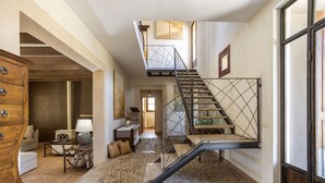 A spacious interior with a staircase, a wooden cabinet, a lamp, and a patterned floor. - Fantastic villa with 4 bedrooms, 3 bathrooms, wifi, barbecue, terraces and pool (Binissalem)