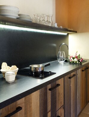 Enjoy cooking in this kitchen with a stainless steel induction cooktop, single burner, and ample counter space.