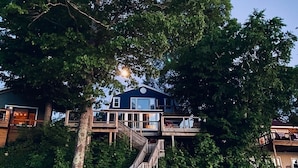 Een meerlaags huis met een houten trap naar een terras.
