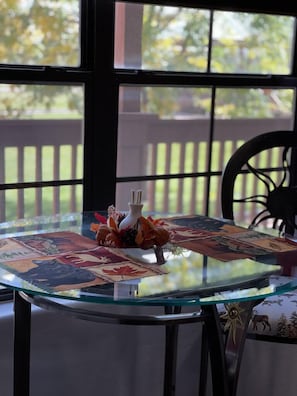 Enjoy meals in style with a dining table set amidst lush greenery and a serene view.