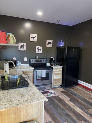 Enjoy cooking in this well-equipped kitchen with a refrigerator, stove, and sink.