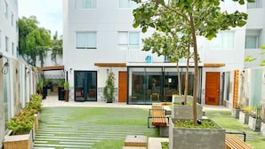 A courtyard with a central pathway, seating areas, and planters.