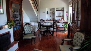 A dining area with a wooden table, chairs, and a staircase leading to another room.
