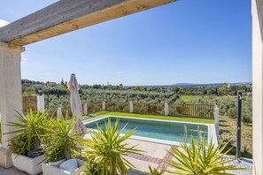 Una piscina con vistas a un paisaje verde y colinas distantes.