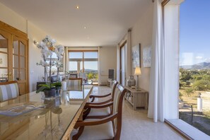A spacious dining area with a glass table, wooden chairs, and a view of the countryside. - Modern villa with 3 bedrooms, 2 bathrooms, wifi, terraces and pool (Inca)