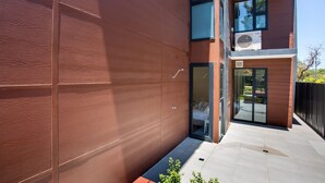 A modern building with a large glass entrance, a visible air conditioning unit, and a clean, tiled exterior. - Husky Sands - Pet Friendly - 5 Mins Walk to Beach (Huskisson)