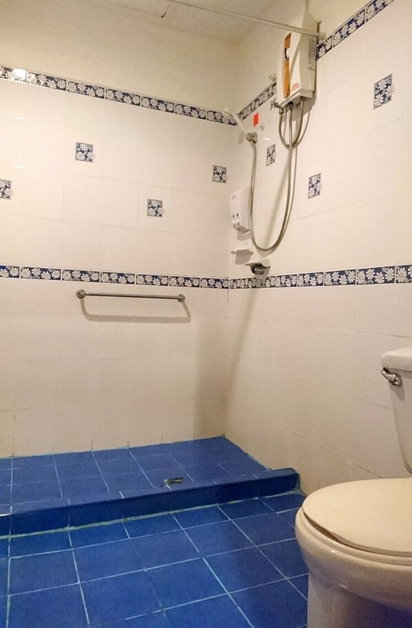 A bathroom with a shower area, a toilet, and a handrail. - Pakse Hotel (Pakse)