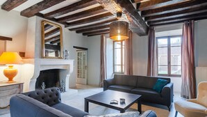 Una sala de estar con chimenea, un sofá, una mesa de centro y una lámpara.