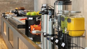 A buffet area with a variety of food items, a coffee station, and beverage dispensers.