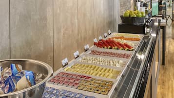 Um buffet com diversos alimentos, incluindo frutas, vegetais e lanches embalados.