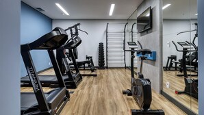 Une salle de sport équipée de tapis de course, d’un vélo elliptique et d’un vélo d’appartement.