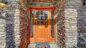 A stone-walled entrance with a wooden door and a welcome mat. - Pagosa Peak Mountain Views (Pagosa Springs)