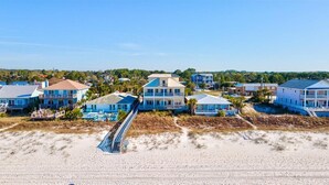 A beachfront hotel with multiple buildings, a swimming pool, and a beach access walkway.