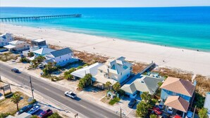 A coastal area with a beach, a pier, and residential buildings.