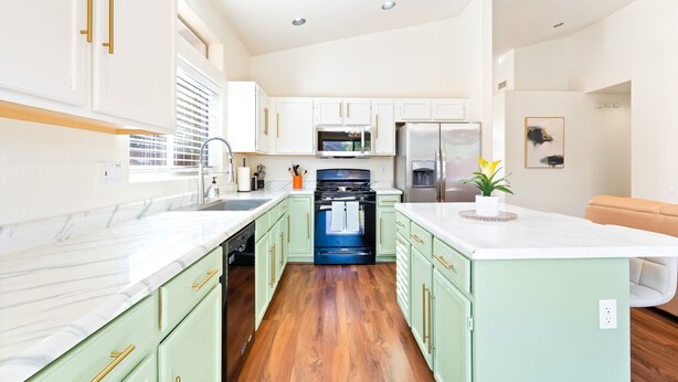 A modern kitchen with white cabinets, a marble countertop, and a central island. - Catalina Serenity Paradise 4 Bed 2 Bath (Tucson)