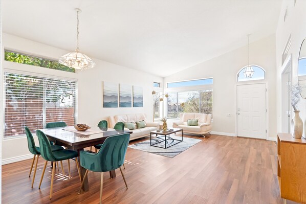 A spacious living room with a dining area, large windows, and a view of the outdoors.