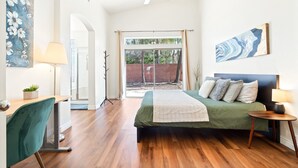 A bedroom with a bed, a desk, a chair, a lamp, and a painting on the wall. - Catalina Serenity Paradise 4 Bed 2 Bath (Tucson)