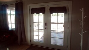 Une pièce avec un plancher en bois, une porte dotée d’une fenêtre et un porte-manteau.