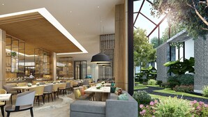 A modern restaurant with multiple dining areas, a bar, and a view of a garden. - Holiday Inn Chengde Park View by IHG (Chengde)