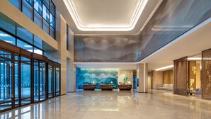 A modern hotel lobby with a reception desk, seating area, and large windows. - Holiday Inn Chengde Park View by IHG (Chengde)
