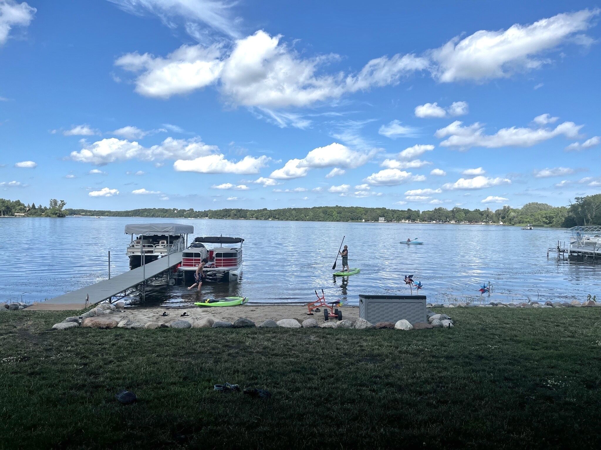 Une jetée au bord du lac, dotée d’une rampe d’accès à l’eau abritée, de kayaks et d’un petit bateau.