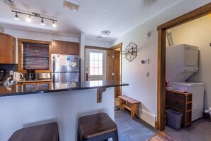 A kitchen with a central island, wooden cabinets, a built-in oven, and a refrigerator.