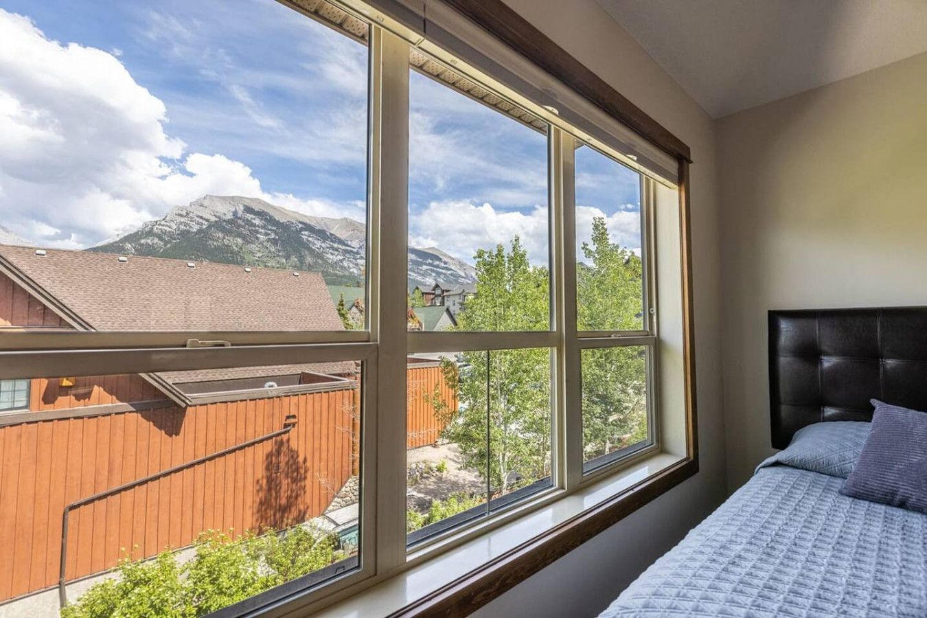 Ein Schlafzimmer mit einem großen Fenster und Blick auf die Berge.