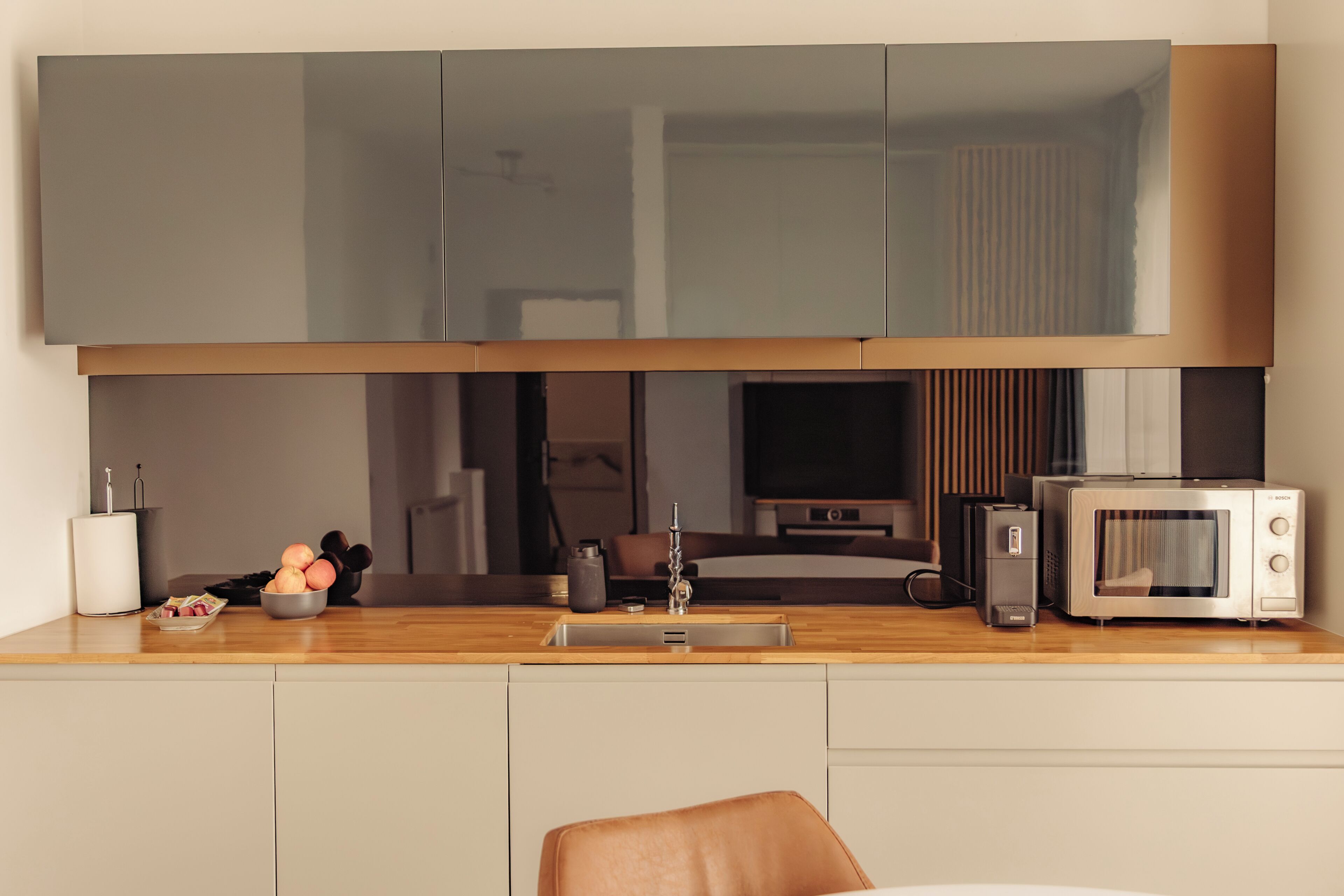 A modern kitchen with a built-in microwave, toaster, and sink.