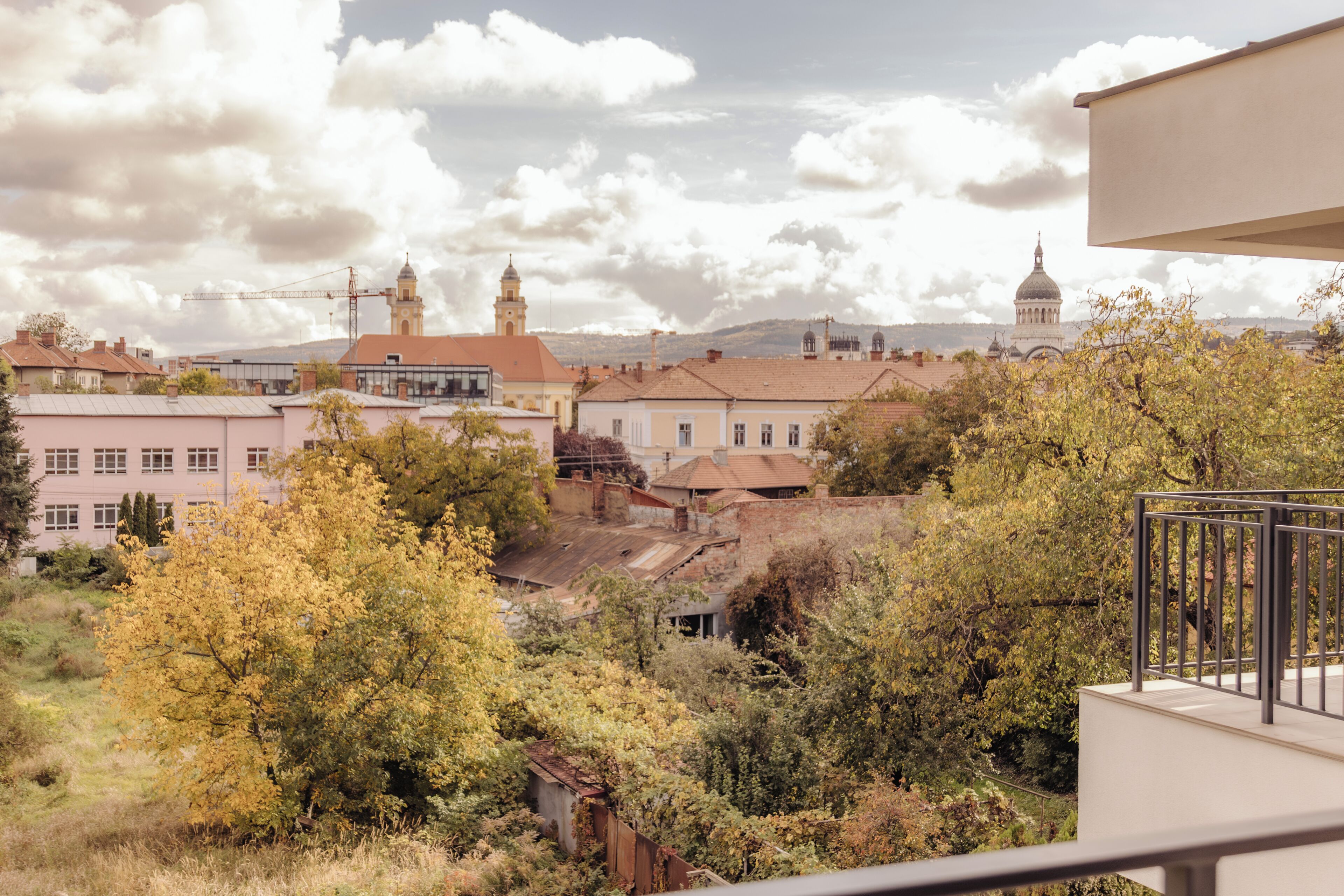 A view of a town with buildings, trees, and a distant dome structure.