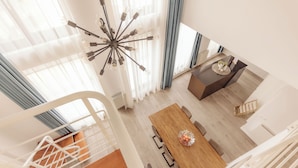 Un interior moderno con zona de comedor, escalera y vista al espacio de la sala.