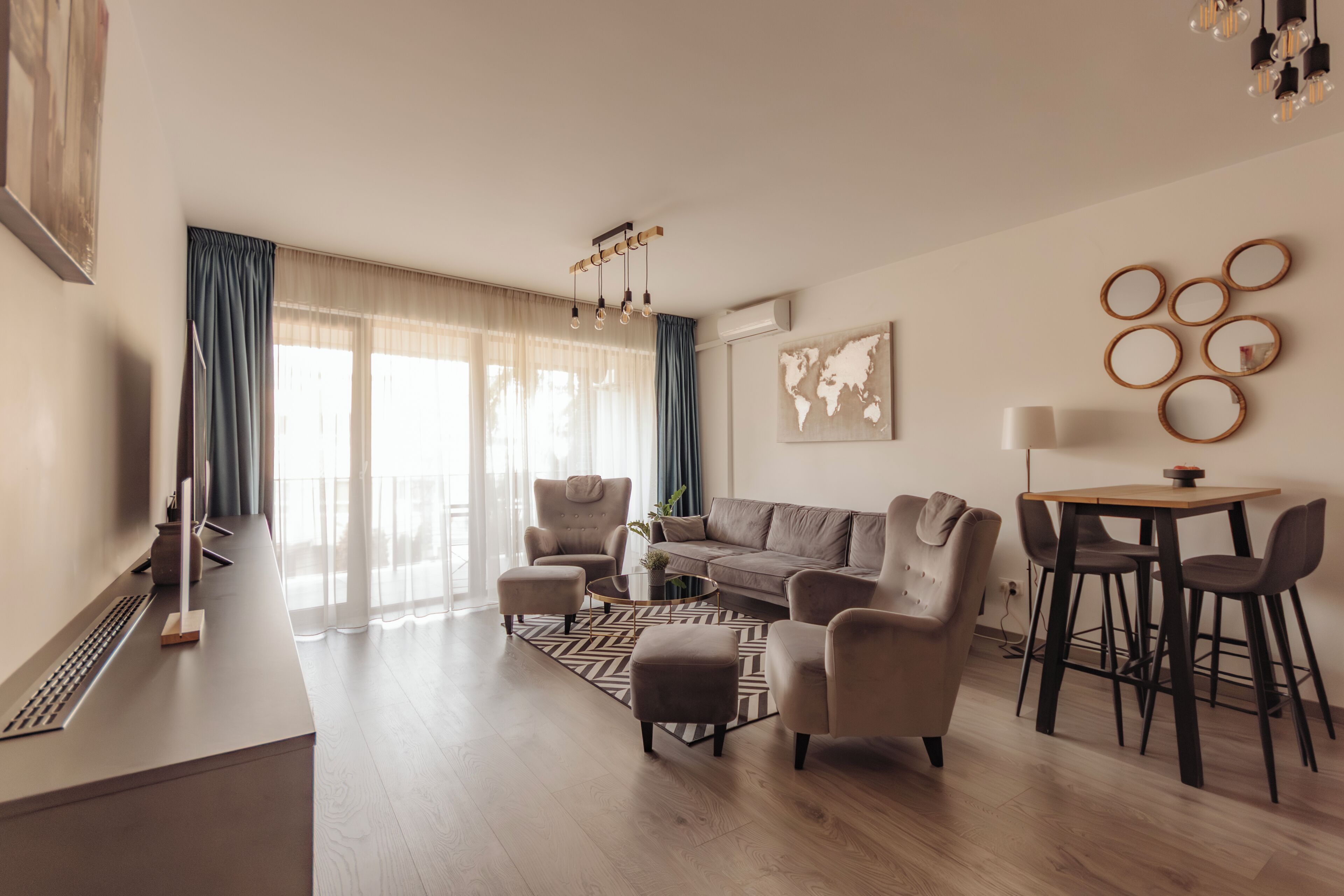 A modern living room with a sofa, armchairs, a coffee table, and a dining area with chairs.