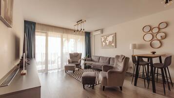 A modern living room with a sofa, armchairs, a coffee table, and a dining area with chairs.