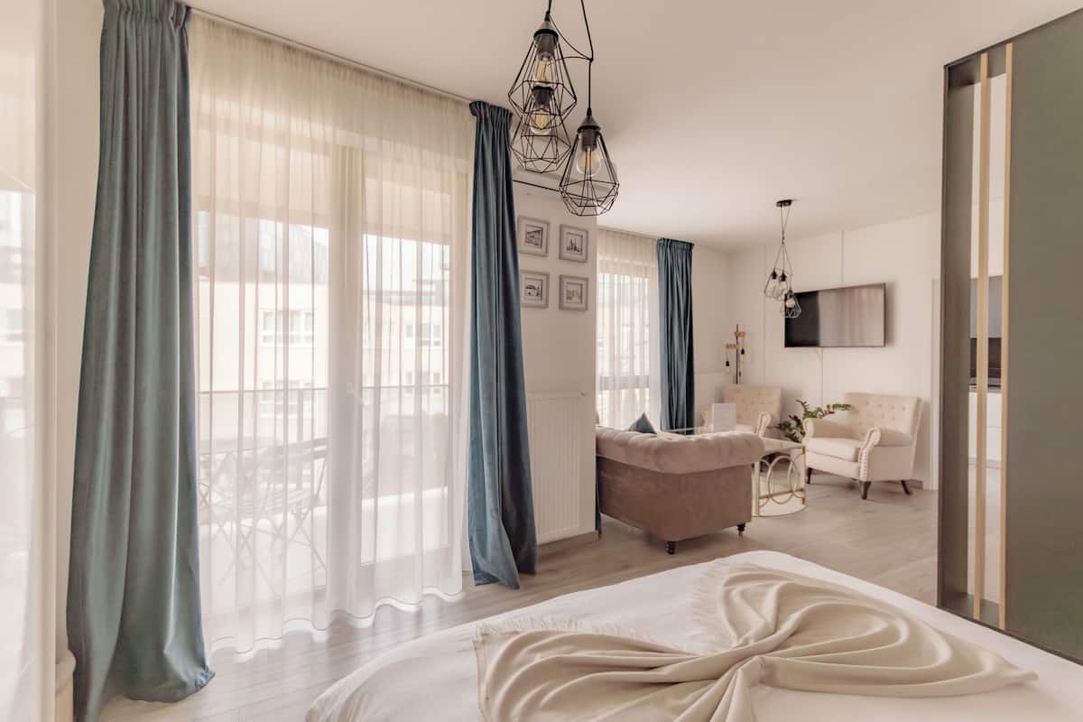 Un dormitorio moderno con una cama grande, un sofá y un televisor.
