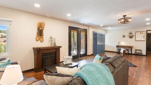 A living room with a fireplace, a sofa, and a dining area. - Lakefront duplex property, nicely finished. 2 bedroom and queen size hide-a-bed. (Divide)