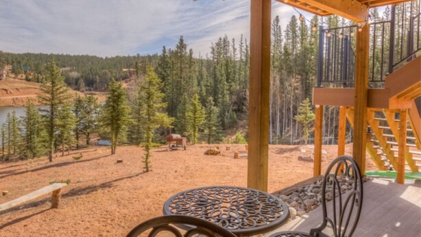 A wooden deck with a view of a forest and a lake. - Lakefront duplex property, nicely finished. 2 bedroom and queen size hide-a-bed. (Divide)