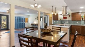 A spacious kitchen with wooden cabinets, a central island, and pendant lighting. - Lakefront duplex property, nicely finished. 2 bedroom and queen size hide-a-bed. (Divide)