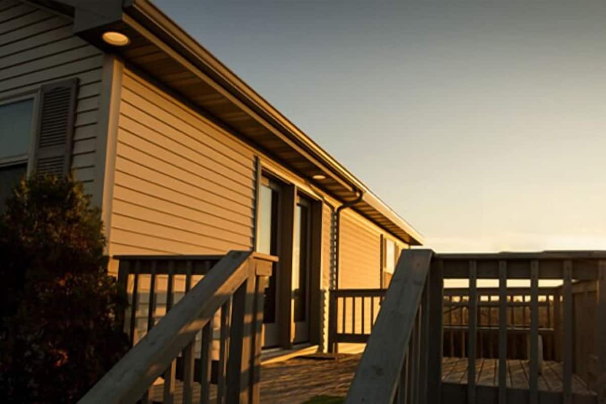 A two-story house with a front porch and a wooden deck.