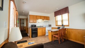 Una cocina funcional con armarios de madera, microondas y estufa.