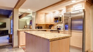 A modern kitchen with a central island, stainless steel appliances, and wooden cabinetry. - 6 Bedroom + 2 Den Duplex 2 Blocks from PC Mountain! Can't beat this place! (Park City)