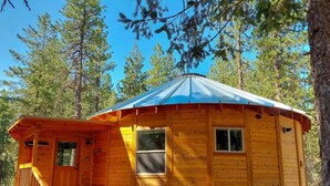 A wooden cabin with a porch, a single window, and a metal roof. - Sunflower Yurt - Mazama special place (Mazama)