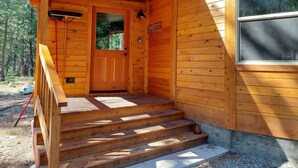A wooden cabin with a front porch, a door, and a window. - Sunflower Yurt - Mazama special place (Mazama)